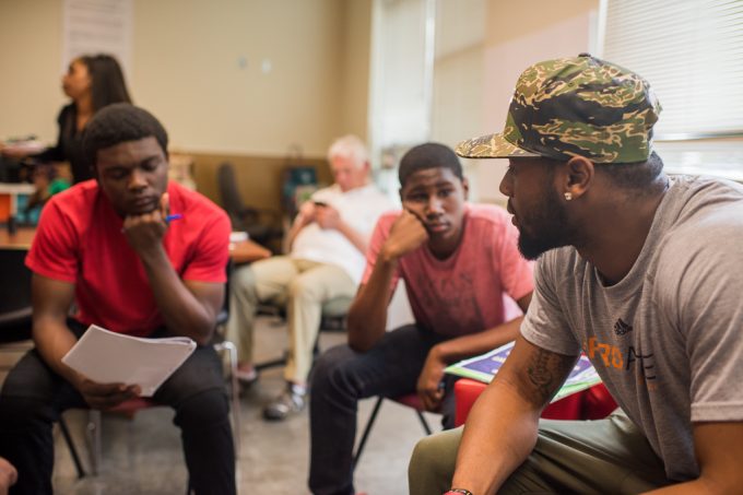 A group of young men talking in a therapy session.