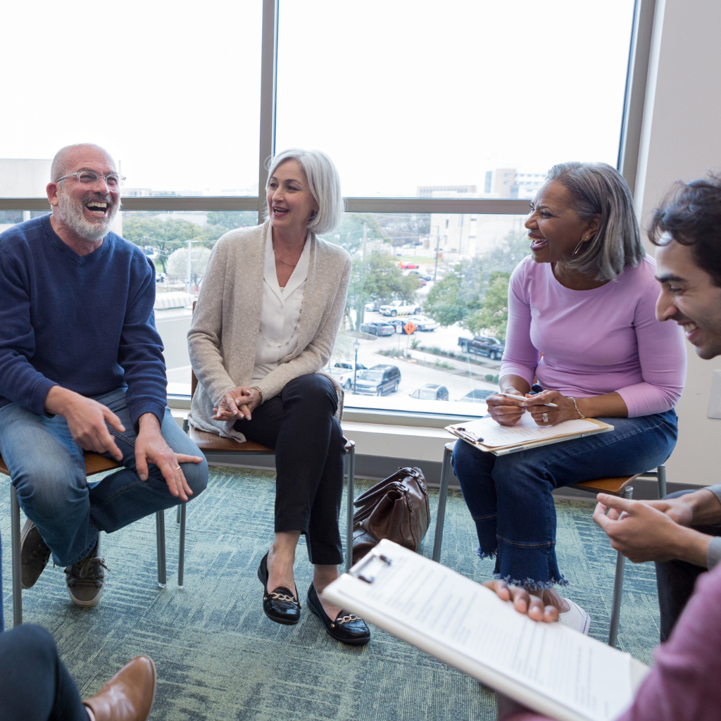 Individuals smiling during a group therapy session