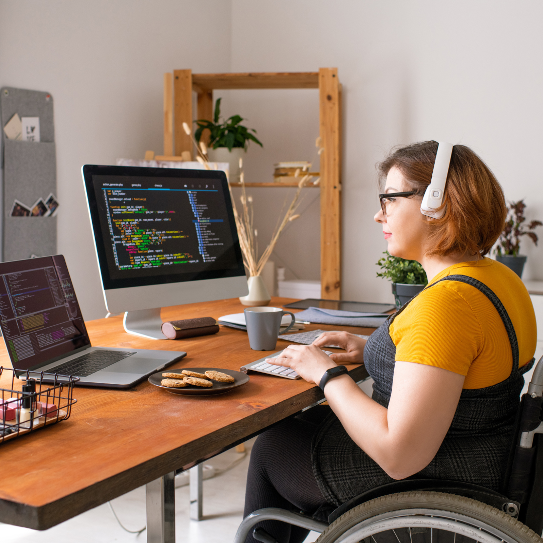 An image of a woman working at an office using a wheelchair.